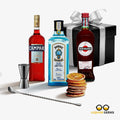 Three liquor bottles with a cocktail shaker, jigger, and cookies on a white background with 'Gifted Pour' branding.